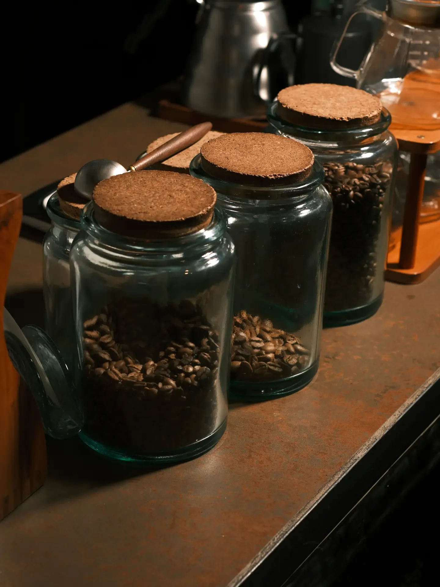 Frascos de vidrio con café tostado en grano sobre la barra