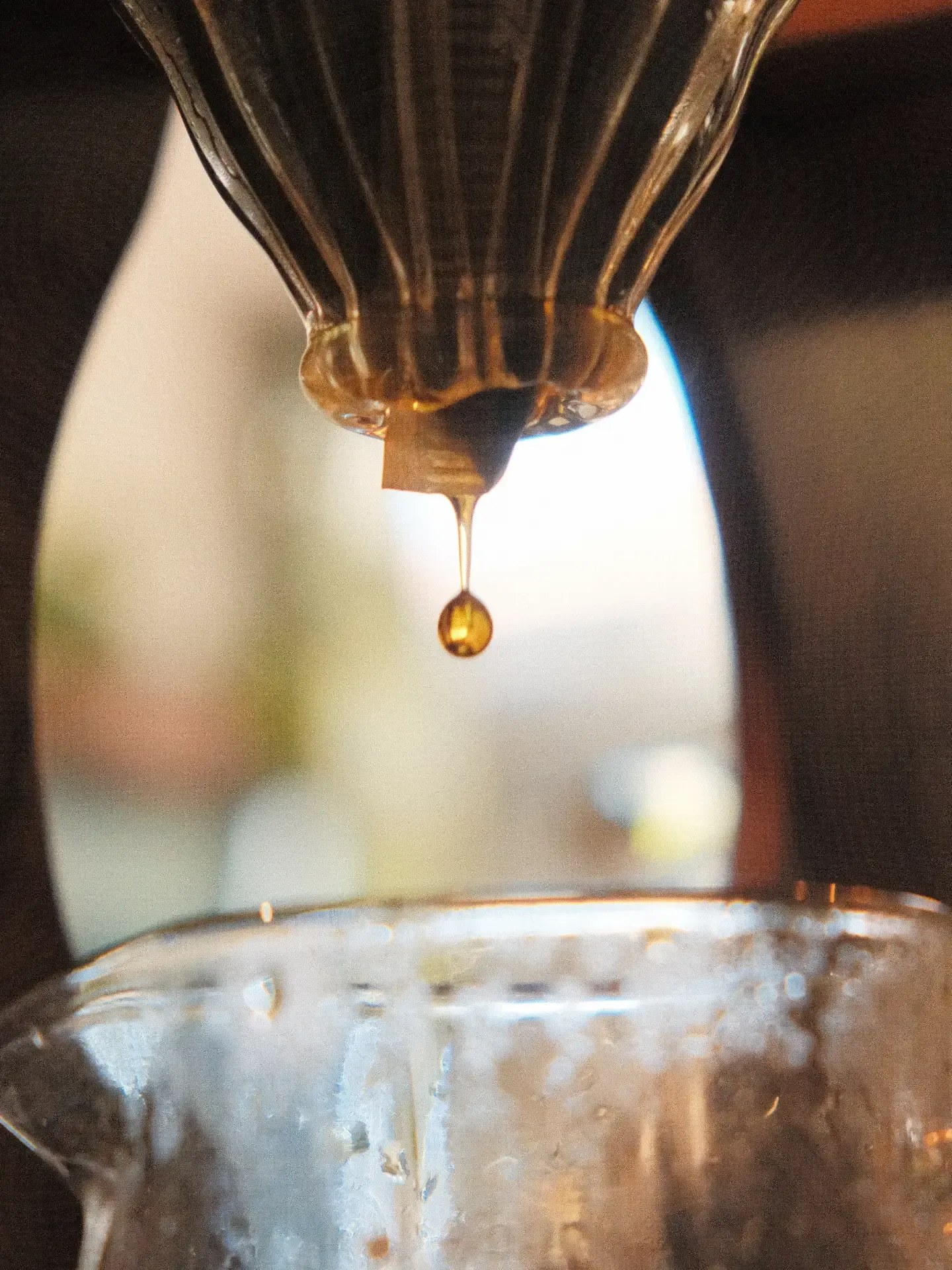 Una gota de café cae del filtro a la jarra de vidrio