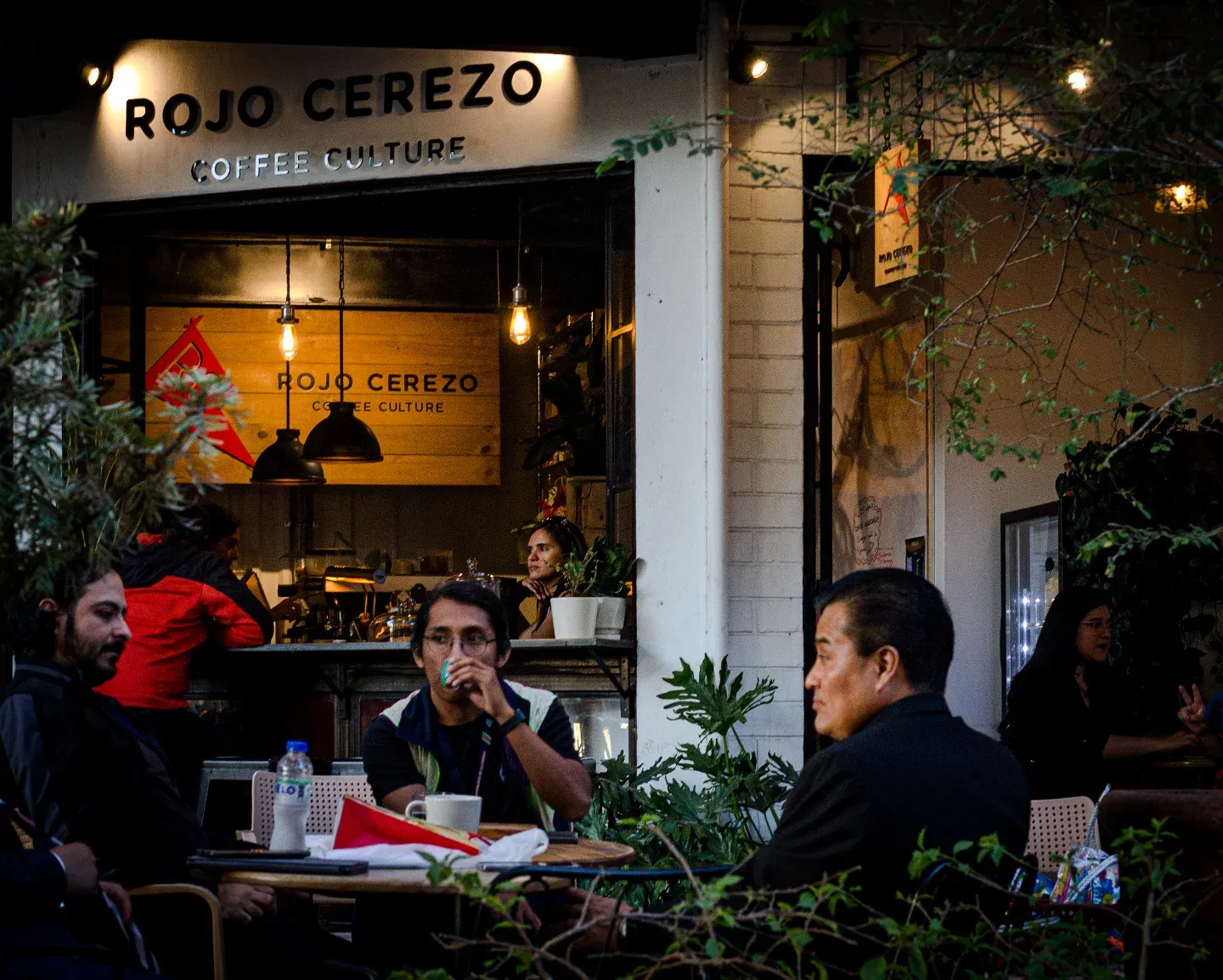 Mesas con clientes en el salón, con el rótulo de Rojo Cerezo al fondo